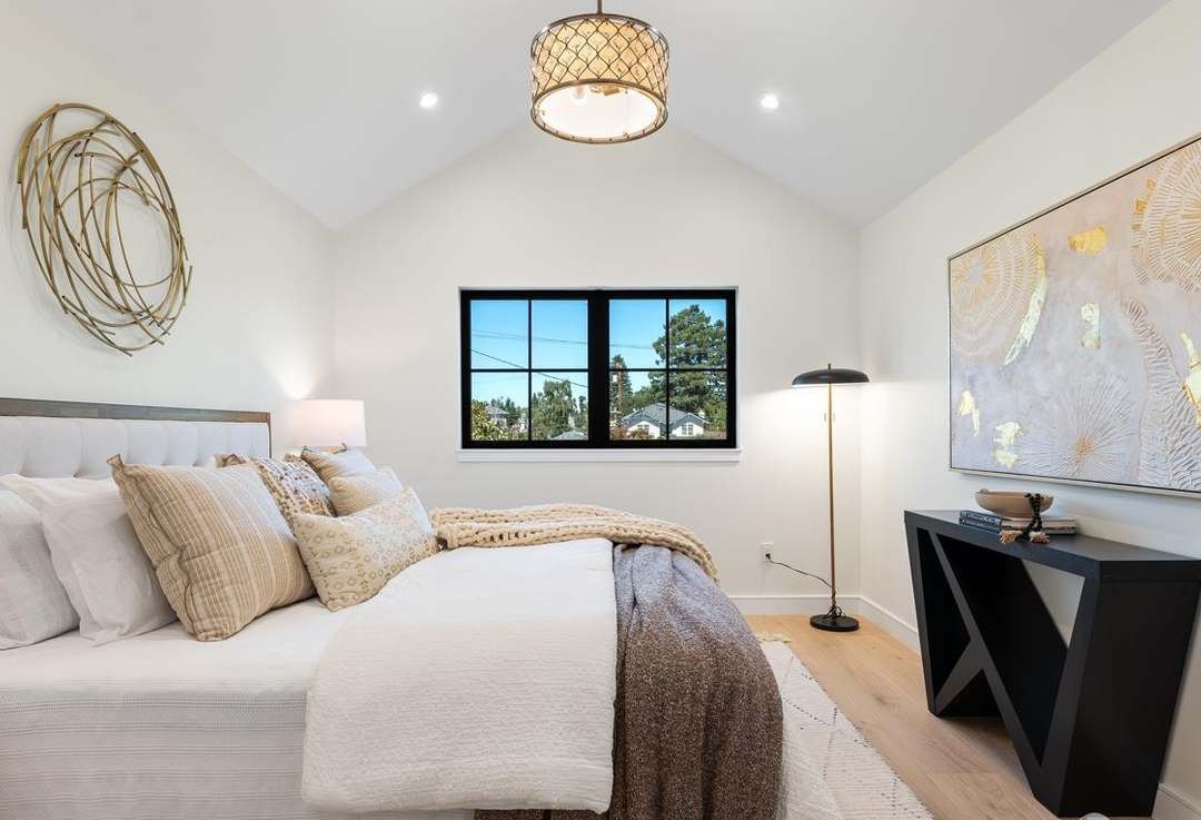 Bedroom with vaulted ceiling and black-framed windows